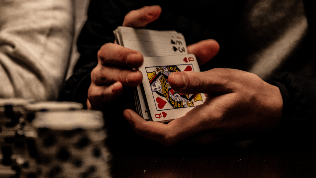 a person is holding a card in their hand while playing poker