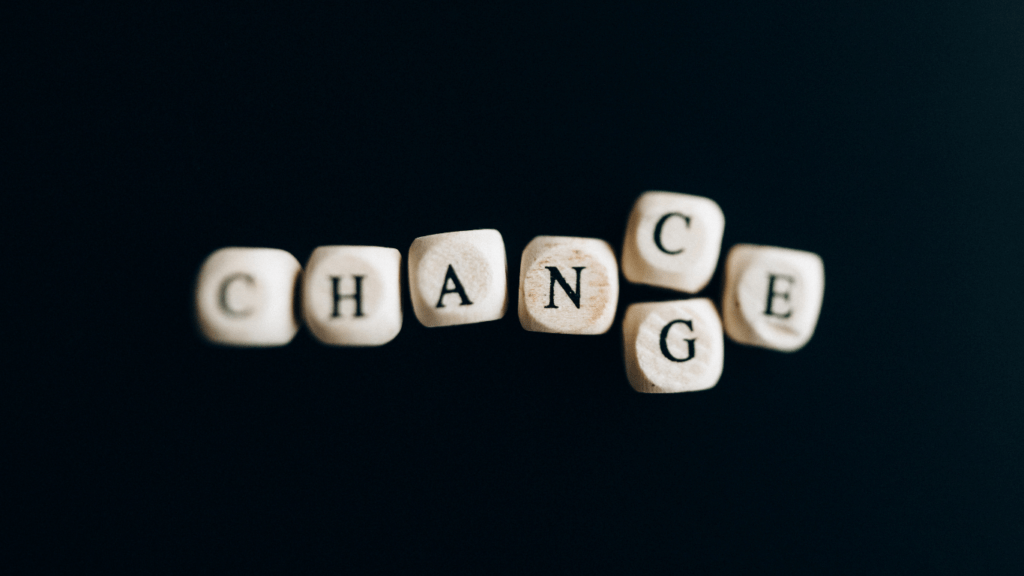 the word change spelled with wooden blocks on a black background