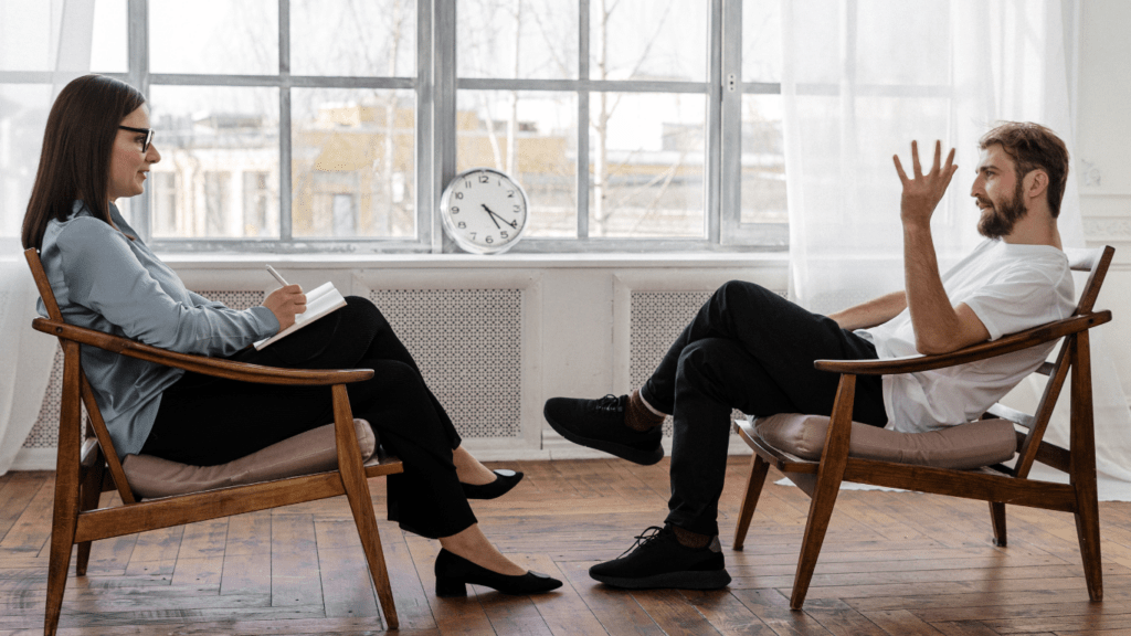 Two people sitting in chairs talking to each other