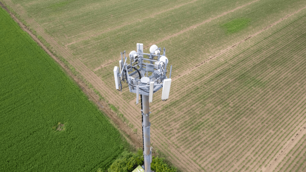 a cell phone tower in the middle of a grassy field