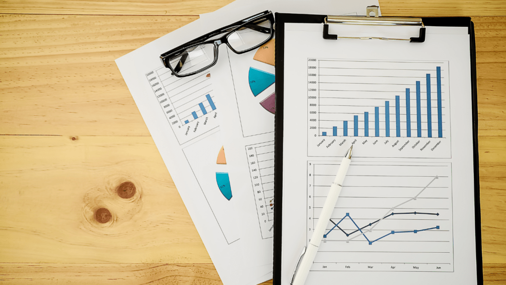 a clipboard, pen and glasses on a wooden table stock photo