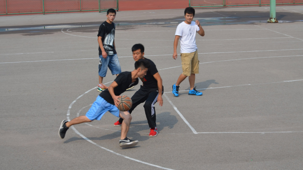 a group of people playing basketball on an outdoor court