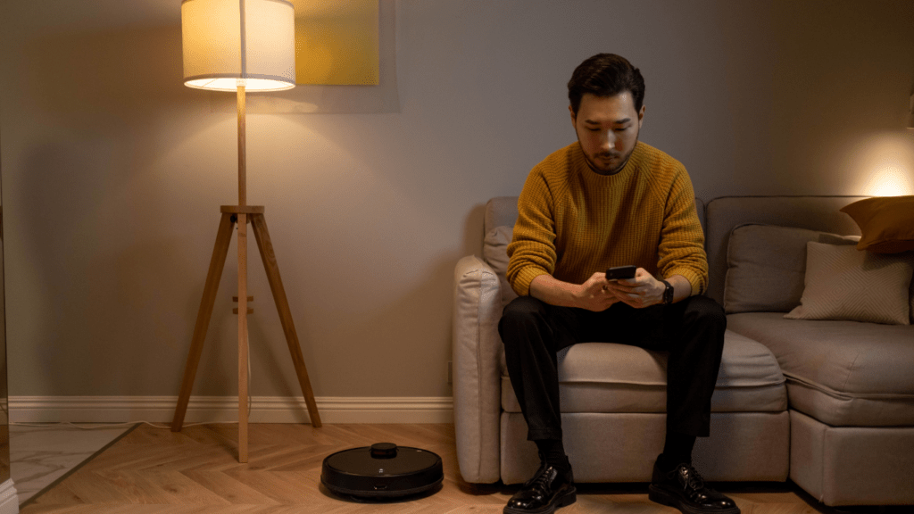 a person holding an iPhone while sitting on a couch