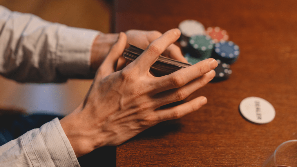 a person is holding a card in their hand while playing poker