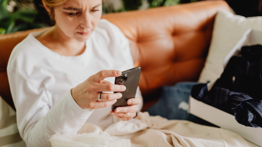 a person is sitting on a couch and holding up their phone