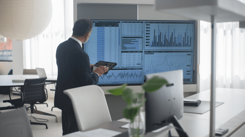 people working on a laptop with a stock market chart on the screen