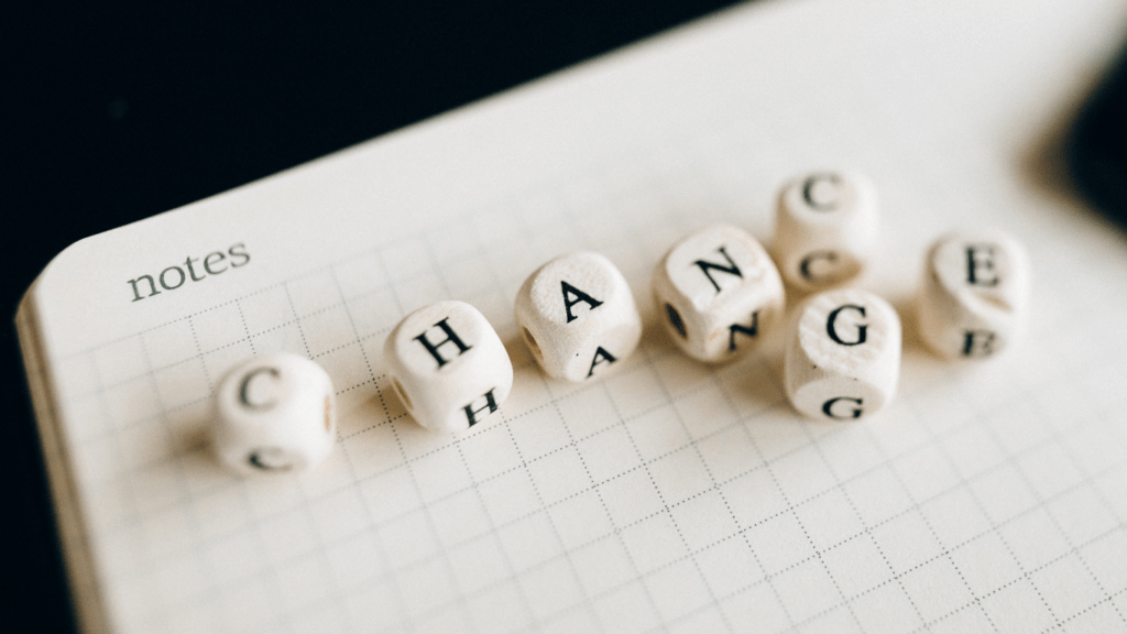 the word change spelled with wooden blocks on a black background